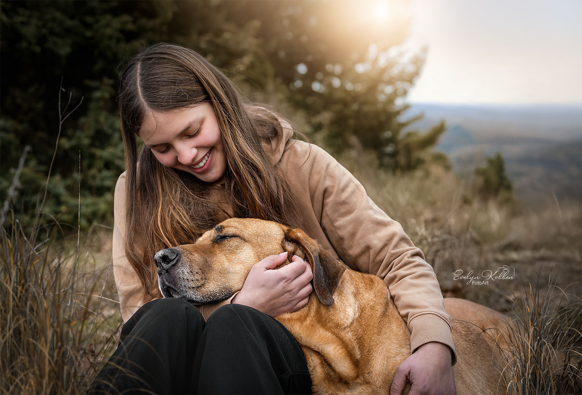 Mädchen kuschelt mit ihrem Broholmer Hund