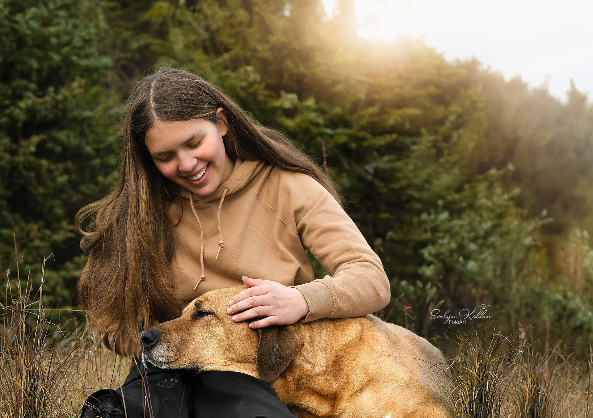 Broholmer Hund in der Natur zusammen mit einem Mädchen, der Hund kuschelt mit dem Mädchen